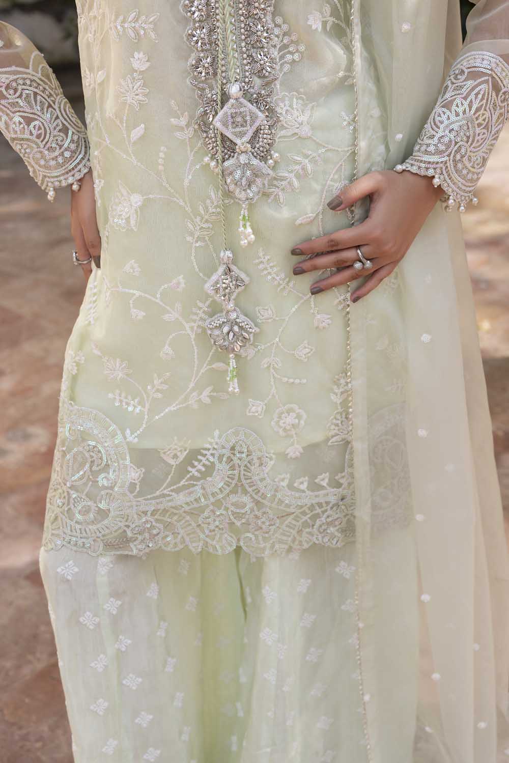 Light green embroidered traditional outfit with intricate patterns and embellishments.